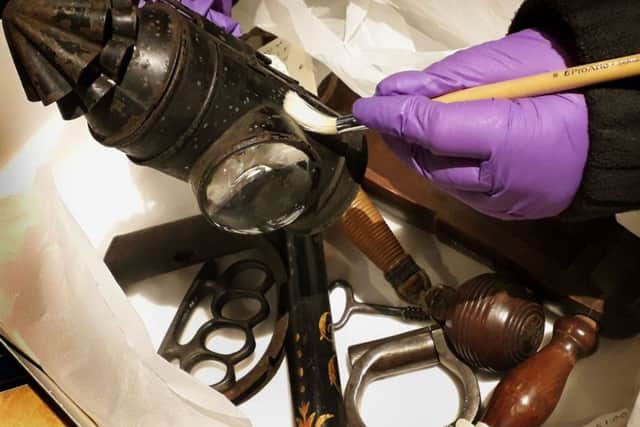 A member of staff at Melton Carnegie Museum cleans equipment used by Victorian police officers in Leicestershire EMN-190129-150701001