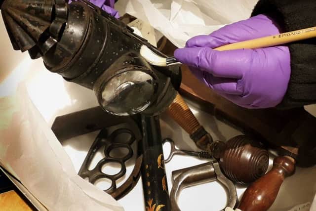 A member of staff  at Melton Carnegie Museum cleans equipment used by Victorian police officers in Leicestershire EMN-190129-150701001