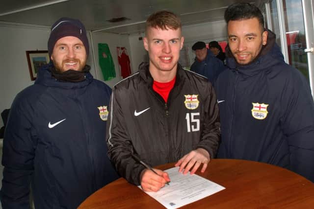 Kyle Reek signs on the dotted line with Melton Town co-manager Tom Manship (left) and Nathan Arnold EMN-190502-083438002