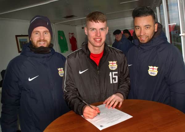 Kyle Reek signs on the dotted line with Melton Town co-manager Tom Manship (left) and Nathan Arnold EMN-190502-083438002