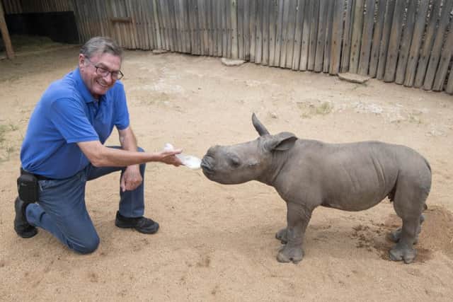 Lord Ashcroft feeds Rainbow, a two month orphaned rhino, during the Footprints of Hope project in South Africa which he sponsored EMN-190131-133842001