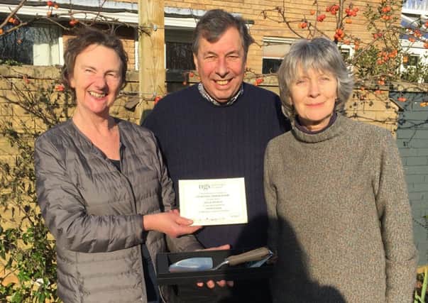 Rose Dejardin - who is stepping down after many years as county organiser - presenting, on behalf of the National Garden Scheme, an engraved trowel to David and Jeffy Wood who have opened their garden at Townsend House, Wing for ten years PHOTO: Supplied