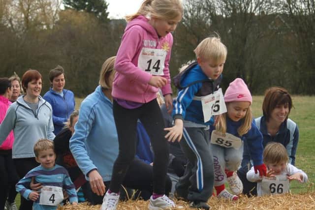 Thrussington Fun Run - parents and toddlers jump the straw bale in the first race PHOTO: Tim Williams EMN-190219-180438002