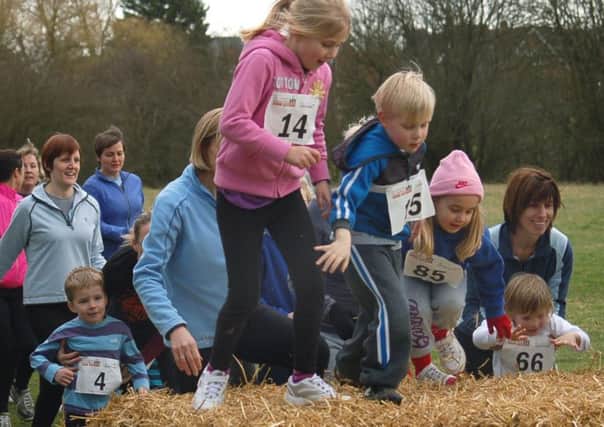Thrussington Fun Run - parents and toddlers jump the straw bale in the first race PHOTO: Tim Williams EMN-190219-180438002