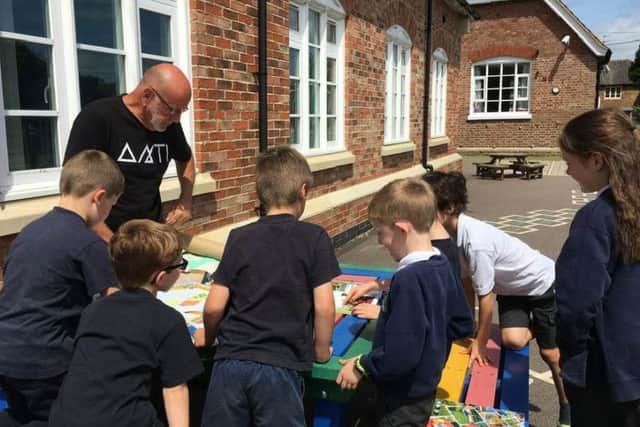 Redmile parish councillor Ian Lowther listening to the ideas of the pupils at Redmile Primary School about the design of their new playpark EMN-190316-160404001
