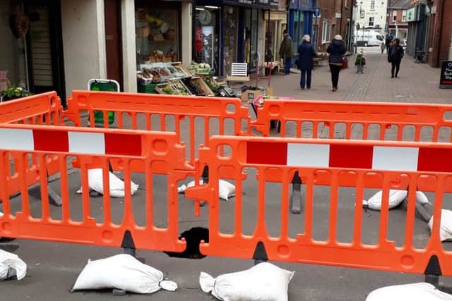 The scene in King Street, Melton, with a large sink hole fenced off by the county council EMN-190318-102435001
