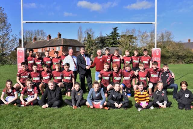 Leicestershire Rugby Union president Steve Rice is pictured presenting the RFU Accreditation documents to Melton RFC club president Tony Middleton and safeguarding officer Andrew Thorpe, with the Under 15s and some of the newly-formed girls section in support EMN-190326-122228002