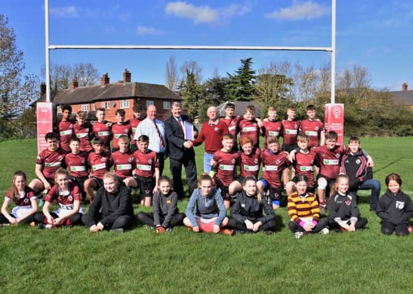 Leicestershire Rugby Union president Steve Rice is pictured presenting the RFU Accreditation documents to Melton RFC club president Tony Middleton and safeguarding officer Andrew Thorpe, with the Under 15s and some of the newly-formed girls section in support EMN-190326-122228002