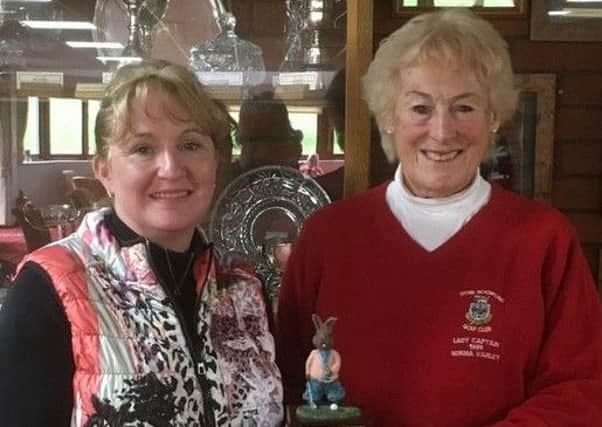 Lady captain Karen Rawson is presented with the Rabbit Trophy by lady president Norma Varley EMN-190904-103037002