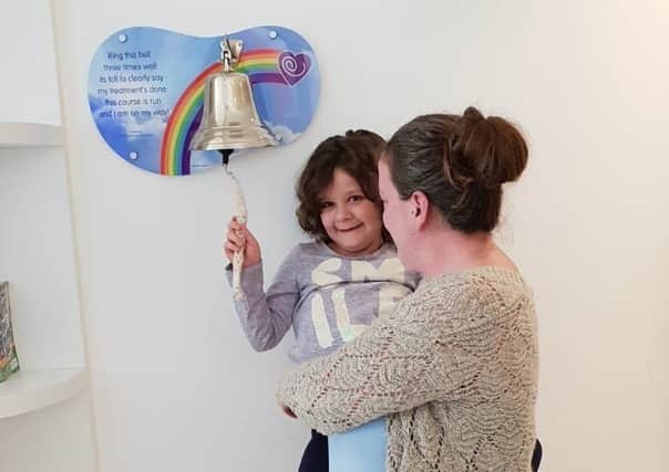 Evie Moore, with mum Helena Isaac, rings the bell at Sheffield Children's Hospital to celebrate being given the all-clear from leukaemia EMN-190418-185157001