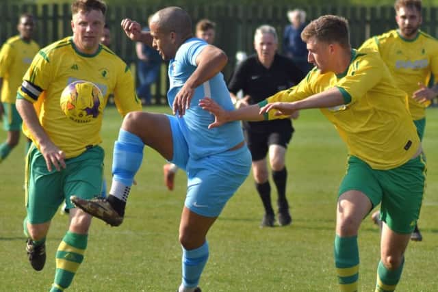 Town sub Kadeem Price keeps his eye on the ball with Holwell skipper Ian Bitmead and Ross Dunlop in close attention EMN-190423-121107002