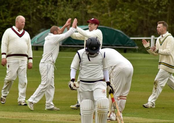 Ben Redwood celebrates a wicket with his Melton team-mates. EMN-190430-113840002