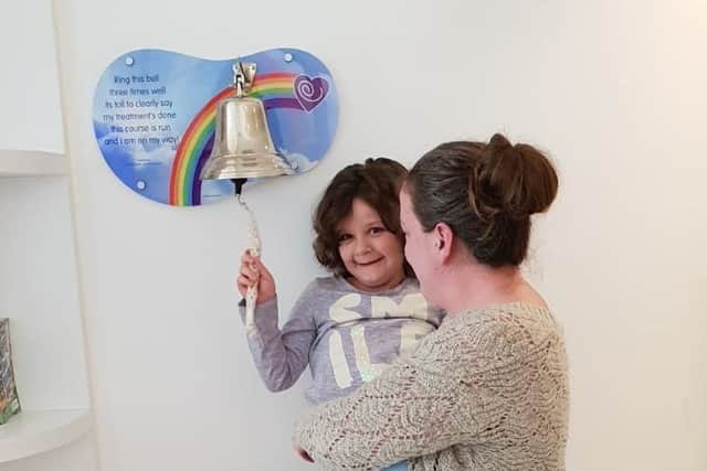 Evie Moore, with mum Helena Isaac, rings the bell at Sheffield Children's Hospital to celebrate being given the all-clear from leukaemia EMN-190430-120022001