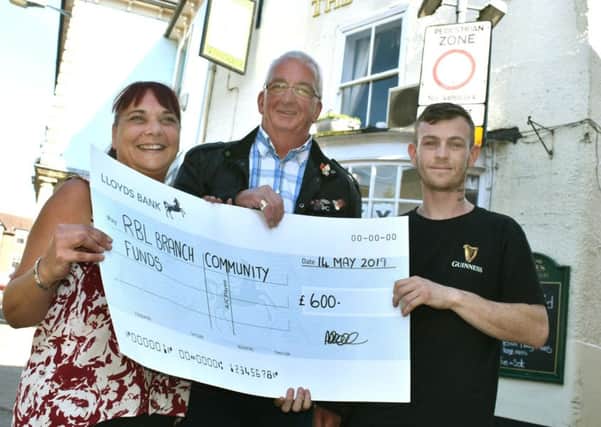 Amanda Bell and Mez Young, from The Grapes pub, in Melton, present a cheque to Ricky Harkness (centre) of the Melton branch of the Royal British Legion as the proceeds from a fundraising event for St George's Day EMN-190515-132059001