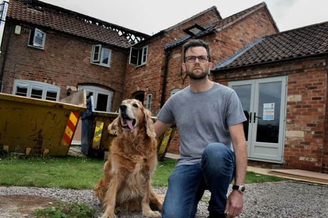 Outside their severely damaged Bottesford home, Richard Watkin, with pet Dillon, who was rescued by a neighbour after it caught fire EMN-190306-174442001
