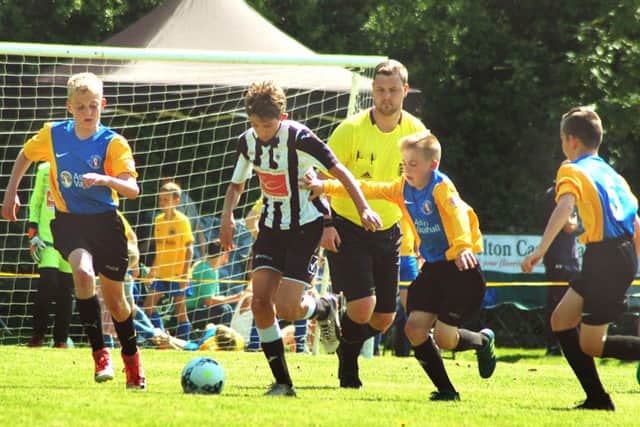 Under 12s winners Mowbray Rangers (yellow and blue) take on French visitors Etoile at last year's festival EMN-190406-184135002
