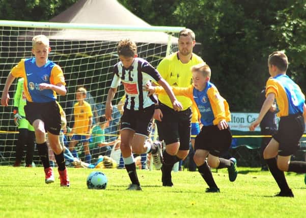 Under 12s winners Mowbray Rangers (yellow and blue) take on French visitors Etoile at last year's festival EMN-190406-184135002