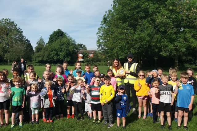 Runners from Melton's junior parkrun with two volunteers holding up the new AED EMN-190613-122008002