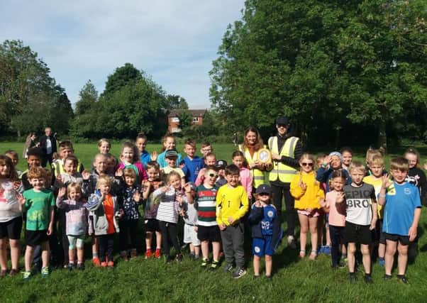 Runners from Melton's junior parkrun with two volunteers holding up the new AED EMN-190613-122008002