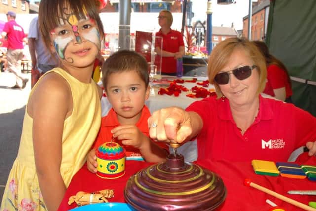 Maia and Jack Paige learn all about traditional childrens' toys with Heather Woodhouse from the Carnegie Museum at Paint The Town Red EMN-190621-091546001