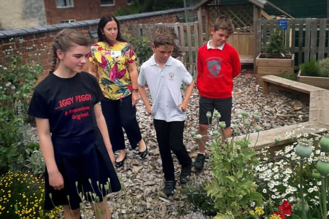 Pupils walk through the new Brownlow Primary School garden with Mel Swainston from sponsors, The Melton Building Society EMN-190715-144702001