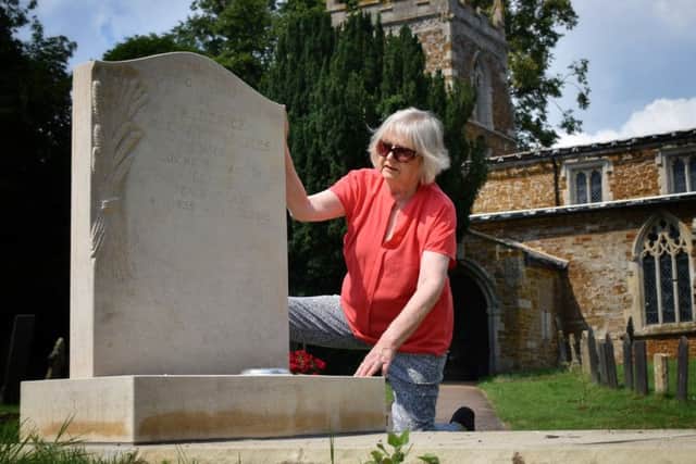 Elaine Holmes by her husband's gravestone, which she has been told to remove from Goadby Marwood Church because it did not have proper permission EMN-190724-111320001