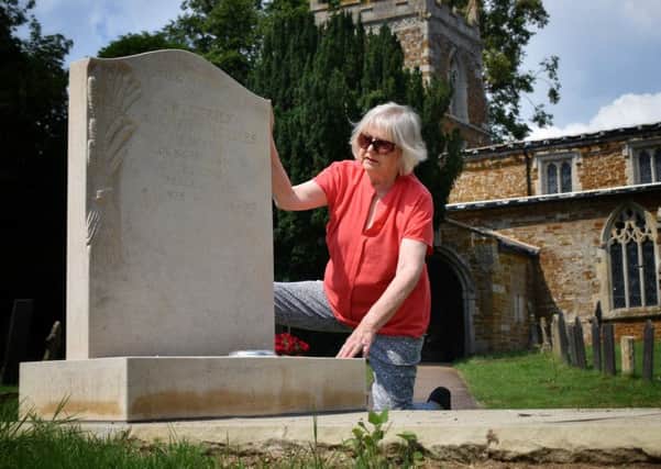 Elaine Holmes by her husband's gravestone, which she has been told to remove from Goadby Marwood Church because it did not have proper permission EMN-190724-111320001