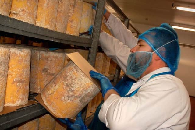 Cheeses are turned daily during the maturation stage at Long Clawson Dairy EMN-190724-131324001