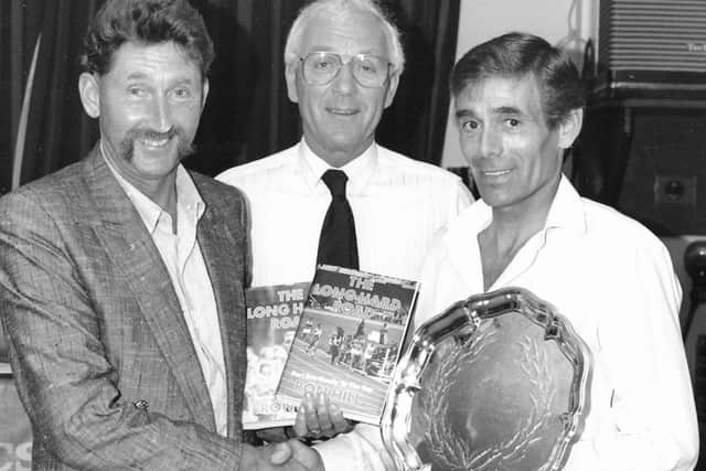 Ron Grove (right) receives a special award to mark his 50th birthday from fellow running legend Ron Hill (left) and Jim Bishop, of Stilton Striders EMN-190309-104159001