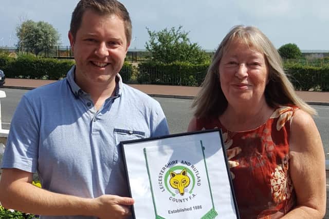 Anne receives her gift from Leicestershire and Rutland County FA business development officer Jamie Clarke EMN-191009-153417002