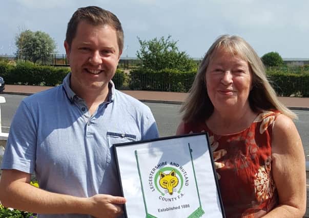 Anne receives her gift from Leicestershire and Rutland County FA business development officer Jamie Clarke EMN-191009-153417002