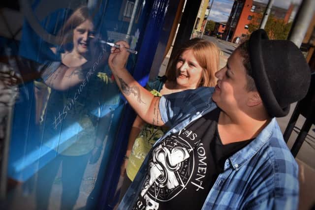 Helen Walters, with Charlie Donovan, add to the public artwork to mark World Suicide Prevention Day outside the BeerHeadZ micropub in Melton EMN-190913-111620001