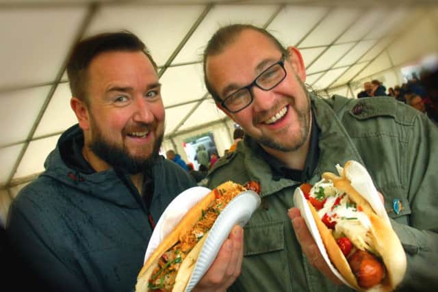 Jamie Russell and Jeremy Smyth-Osborne tackle their bratwurst hot dogs PHOTO: Tim Williams EMN-180810-162601001