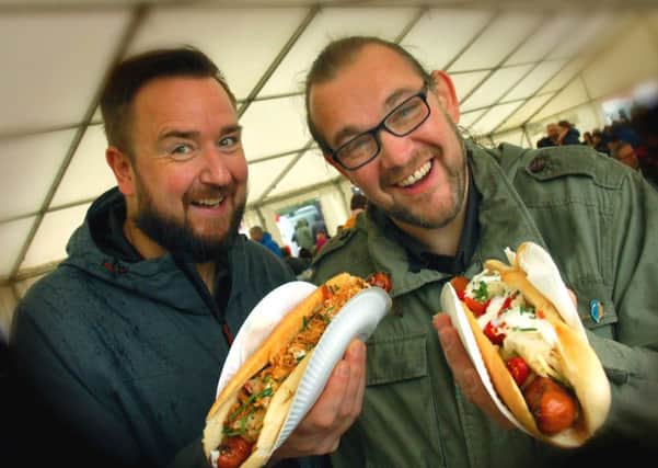 Jamie Russell and Jeremy Smyth-Osborne tackle their bratwurst hot dogs PHOTO: Tim Williams EMN-180810-162601001