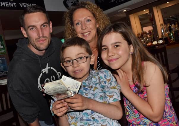 Genny B landlady Louise James with Riley Masters (5), his dad Tristram and sister, Lily-Mae, after handing over ?400 raised by regulars to help send Riley on a special holiday EMN-190710-103954001
