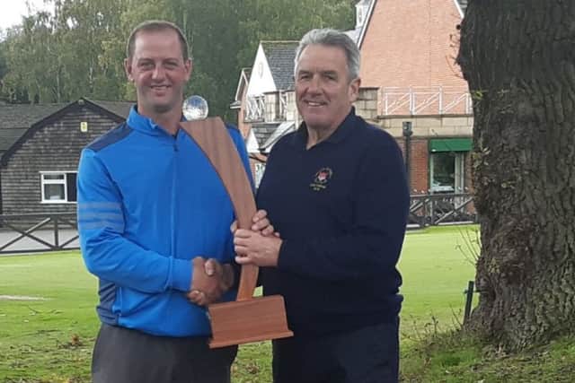 Steve Burton (left) receives the trophy from Melton Golf Club captain Gerry Stephens EMN-191022-161500002