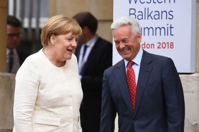 Sir Alan Duncan greets Chancellor Merkel on her arrival at the Western Balkans Summit PHOTO: Supplied EMN-191030-160400001