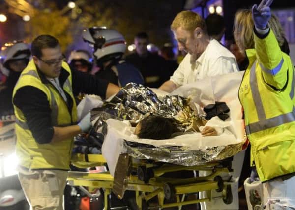 Rescuers evacuate an injured person near the Bataclan concert hall. Picture: AFP/Getty Images
