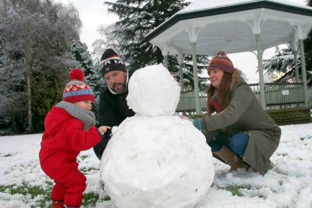 Two-year old Fergus Gallagher puts the finishing touches to his snowman with parents Jason and Emma EMN-160118-110612001