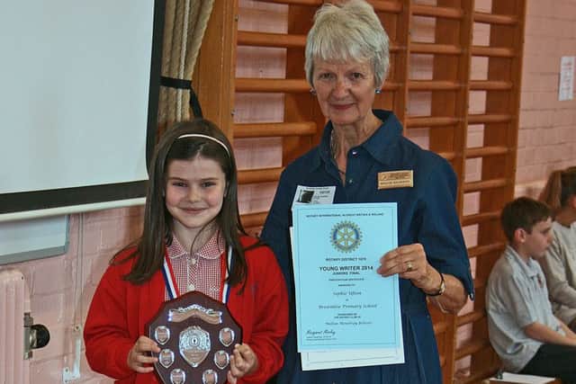 Sophie Ufton, winner of the Rotary Young Writer Competition in 2014, receives her trophy, medal and certificates from Maggie Saunders, of the Rotary Club of Melton Belvoir