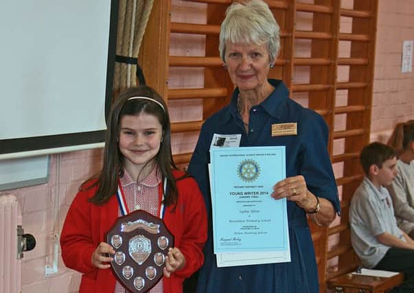 Sophie Ufton, winner of the Rotary Young Writer Competition in 2014, receives her trophy, medal and certificates from Maggie Saunders, of the Rotary Club of Melton Belvoir