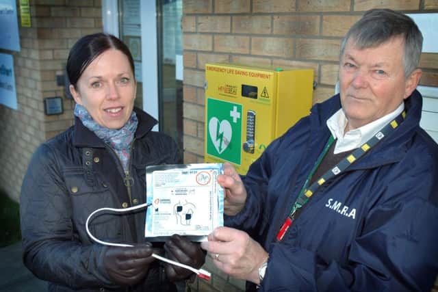 Shout4Residents chairman John Bellamy receives the defibrillator pads from The Melton Building Society's marketing manager Melanie Swainston EMN-160130-105357001