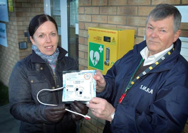 Shout4Residents chairman John Bellamy receives the defibrillator pads from The Melton Building Society's marketing manager Melanie Swainston EMN-160130-105357001