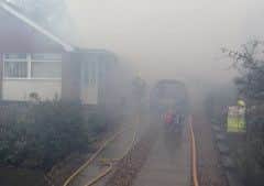 Smoke billows from the garage as firefighters tackle the blaze EMN-160202-145347001