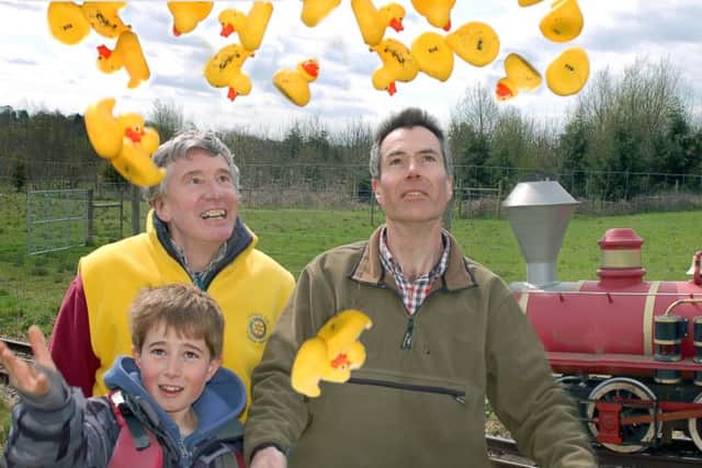 Rotarian David Ward gets help launching the ducks from James and Gavin Howling PHOTO: Tim Williams