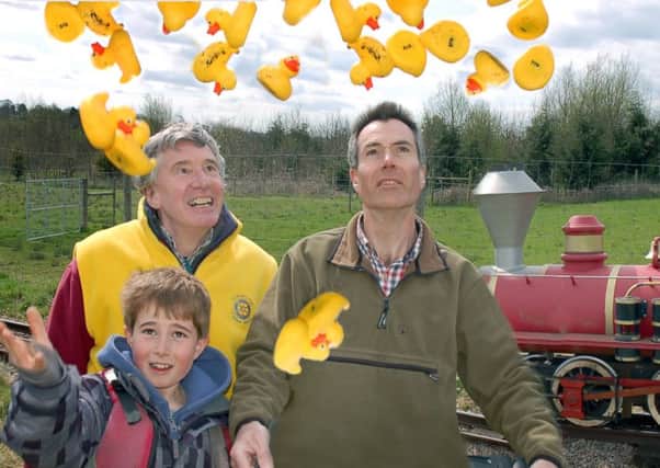 Rotarian David Ward gets help launching the ducks from James and Gavin Howling PHOTO: Tim Williams