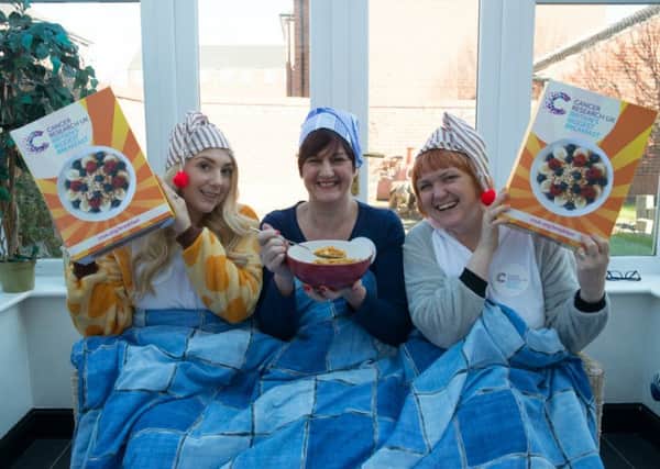 Cancer Research UK's local fundraising manager for Melton, Jayne Sullivan (centre), stages a charity breakfast in bed with colleagues Annie Mitchell (left) and Paula Scaife (right) EMN-160203-110624001