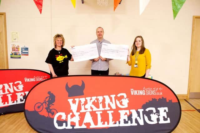 Colin Shearer, chairperson of the Viking Challenge Committee, presents Redmile headteacher Julie Hopkins (left), and Charlotte Marson from the Derbyshire, Leicestershire and Rutland Air Ambulance, with their cheques
PHOTO: Supplied