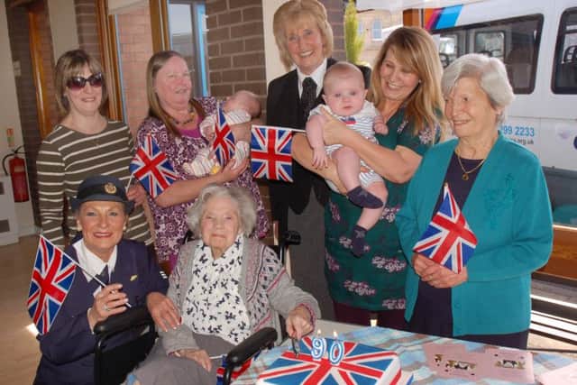 Cutting one of the cakes is 90-year-old Barbara Tite. Next to her is Kerry Jean, of Syston, who sang and provided entertainment at the party. On the back row, from left, are carer/driver Ingrid Horton, day care organiser Pam Wright holding tiny Evie-Rose Moss, Jenny Barnes, day care organiser Angie Perduno, who is holding her grandson William Frier, and Marie Perduno EMN-160421-171613001