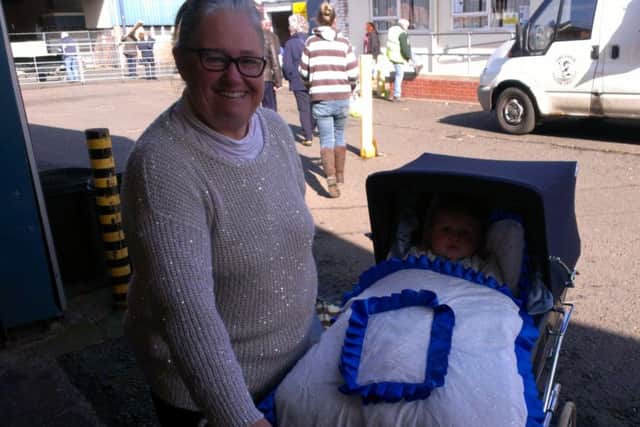 Alfreda Naylor with her 16-month-old grandson, Jensen, swathed in blue and white at Melton Cattle Market EMN-160305-095331001